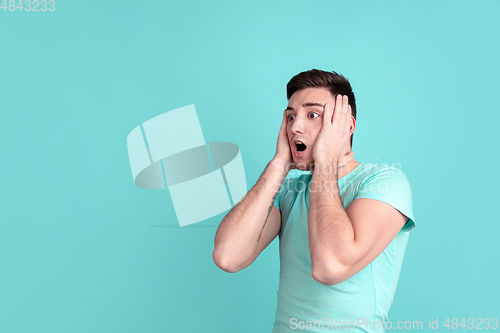 Image of Caucasian young man\'s portrait on blue studio background