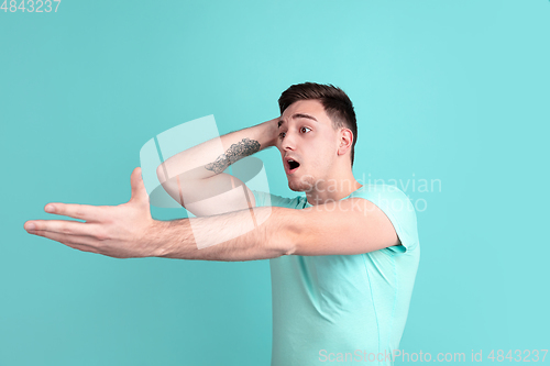 Image of Caucasian young man\'s portrait on blue studio background