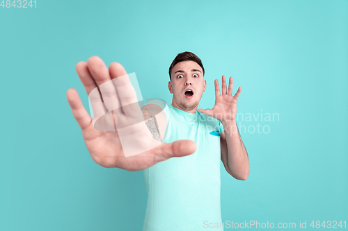 Image of Caucasian young man\'s portrait on blue studio background