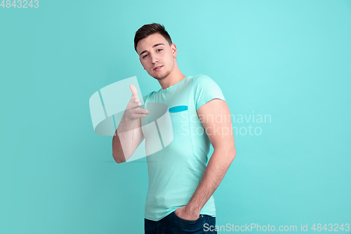 Image of Caucasian young man\'s portrait on blue studio background
