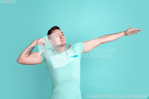 Image of Caucasian young man\'s portrait on blue studio background