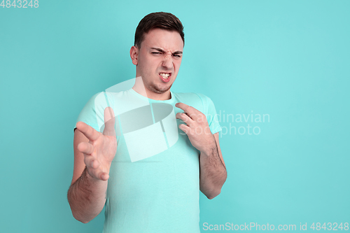 Image of Caucasian young man\'s portrait on blue studio background