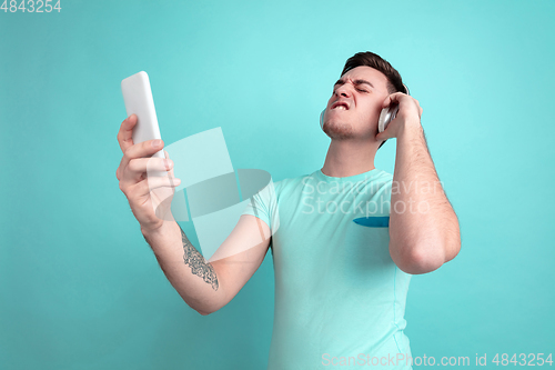 Image of Caucasian young man\'s portrait on blue studio background