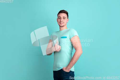 Image of Caucasian young man\'s portrait on blue studio background