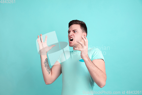 Image of Caucasian young man\'s portrait on blue studio background