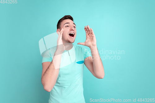 Image of Caucasian young man\'s portrait on blue studio background