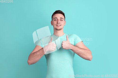 Image of Caucasian young man\'s portrait on blue studio background