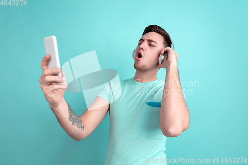 Image of Caucasian young man\'s portrait on blue studio background