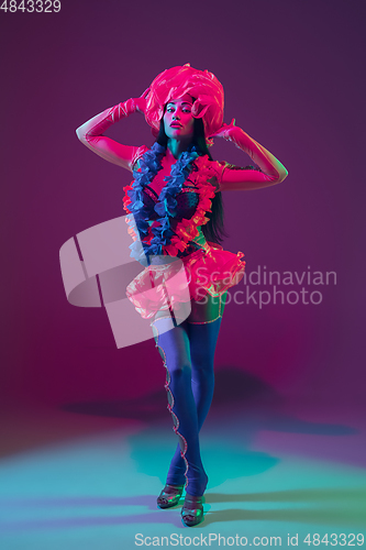 Image of Attractive hawaiian brunette model on purple studio background in neon light