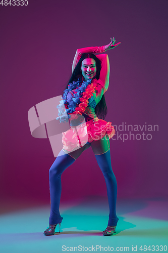 Image of Attractive hawaiian brunette model on purple studio background in neon light