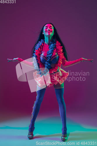 Image of Attractive hawaiian brunette model on purple studio background in neon light