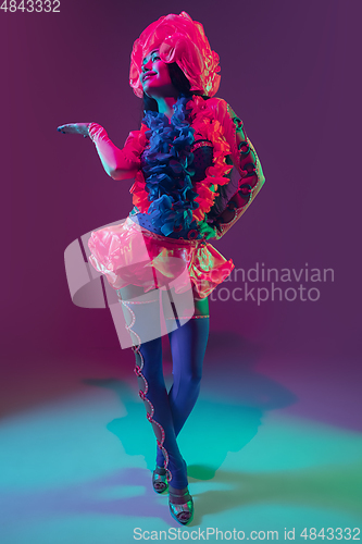 Image of Attractive hawaiian brunette model on purple studio background in neon light