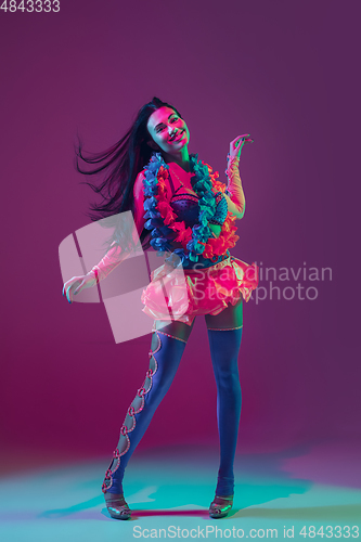 Image of Attractive hawaiian brunette model on purple studio background in neon light