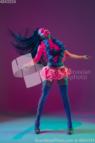 Image of Attractive hawaiian brunette model on purple studio background in neon light