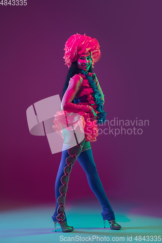 Image of Attractive hawaiian brunette model on purple studio background in neon light