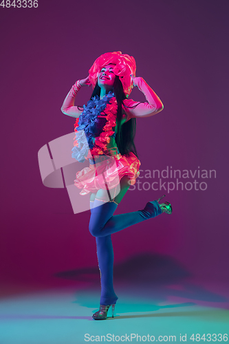 Image of Attractive hawaiian brunette model on purple studio background in neon light