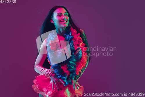 Image of Attractive hawaiian brunette model on purple studio background in neon light