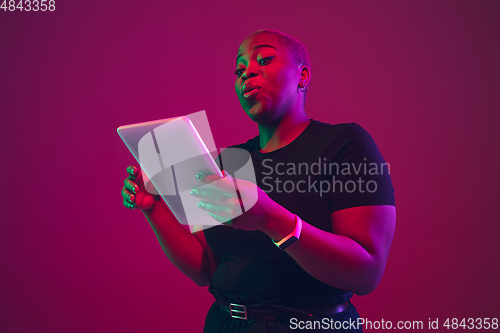 Image of African-american young woman\'s portrait on purple pink background