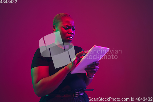 Image of African-american young woman\'s portrait on purple pink background