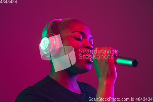 Image of African-american young woman\'s portrait on purple pink background