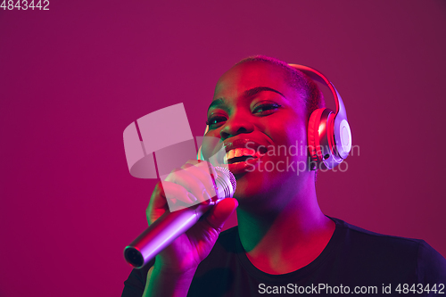 Image of African-american young woman\'s portrait on purple pink background