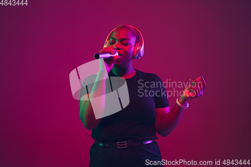 Image of African-american young woman\'s portrait on purple pink background