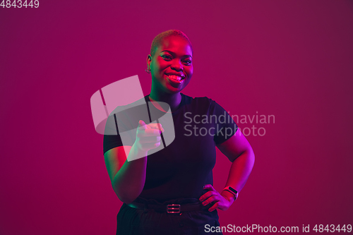Image of African-american young woman\'s portrait on purple pink background