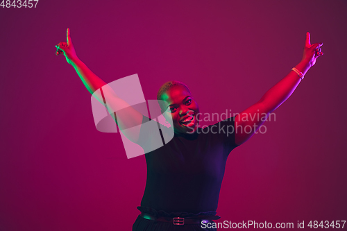 Image of African-american young woman\'s portrait on purple pink background