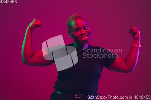 Image of African-american young woman\'s portrait on purple pink background