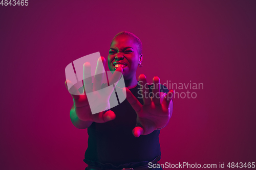 Image of African-american young woman\'s portrait on purple pink background