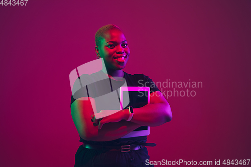 Image of African-american young woman\'s portrait on purple pink background