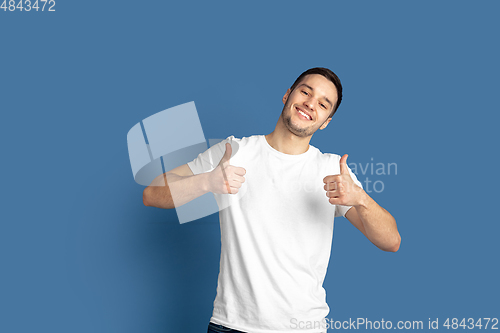 Image of Caucasian young man\'s portrait on blue studio background