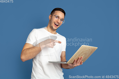 Image of Caucasian young man\'s portrait on blue studio background