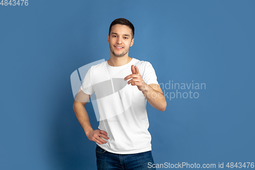 Image of Caucasian young man\'s portrait on blue studio background