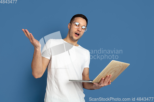 Image of Caucasian young man\'s portrait on blue studio background