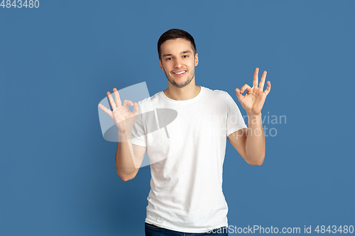 Image of Caucasian young man\'s portrait on blue studio background