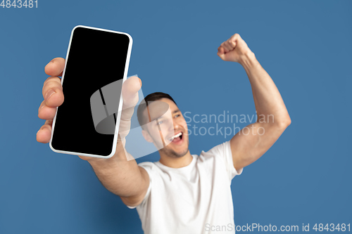 Image of Caucasian young man\'s portrait on blue studio background