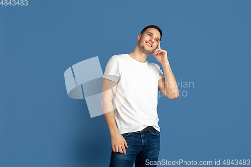Image of Caucasian young man\'s portrait on blue studio background