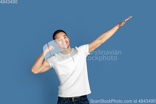 Image of Caucasian young man\'s portrait on blue studio background