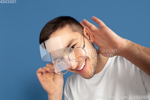 Image of Caucasian young man\'s portrait on blue studio background