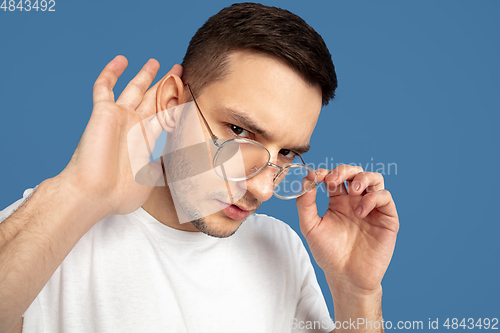 Image of Caucasian young man\'s portrait on blue studio background