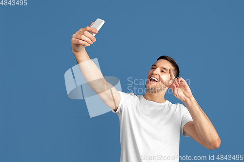 Image of Caucasian young man\'s portrait on blue studio background