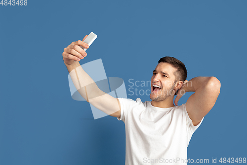 Image of Caucasian young man\'s portrait on blue studio background