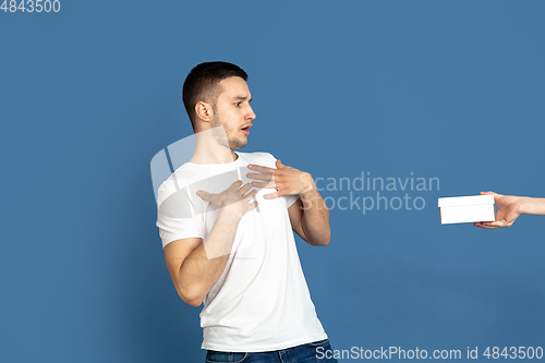 Image of Caucasian young man\'s portrait on blue studio background