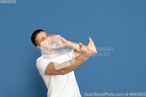 Image of Caucasian young man\'s portrait on blue studio background