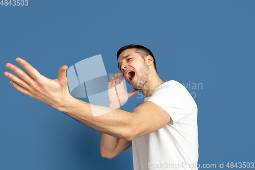 Image of Caucasian young man\'s portrait on blue studio background