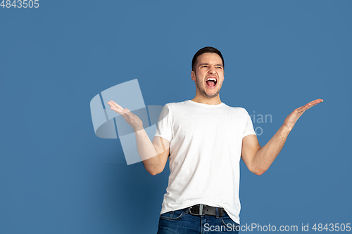 Image of Caucasian young man\'s portrait on blue studio background