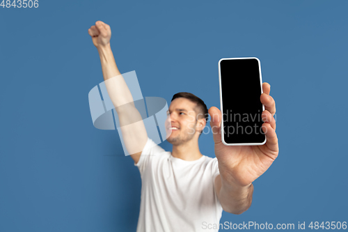 Image of Caucasian young man\'s portrait on blue studio background