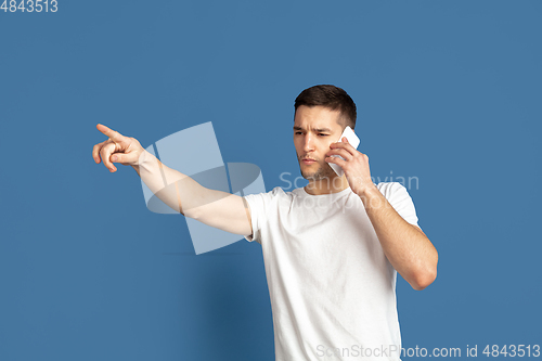 Image of Caucasian young man\'s portrait on blue studio background