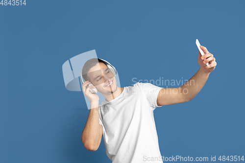 Image of Caucasian young man\'s portrait on blue studio background